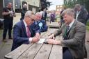 Official - Nigel Farage (left) signing candidacy forms outside the Three Jays pub in Jaywick