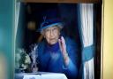 Queen Elizabeth II waves from a railway carriage in 2015