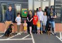 Alison Bradnick cuts the ribbon to celebrate the installation of the new defibrillator, helped by her four children Taliesin, Xander, Hermione, and Aurora and fellow residents of Walpole Meadows, Stansted