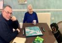 Kevin, Margaret and Maisie the schnoodle enjoy a game of Scrabble at Mountfitchet House