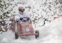 The soapbox from St Joseph's College driving through the foam cloud