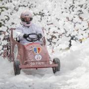 The soapbox from St Joseph's College driving through the foam cloud