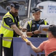 Officers check the details of a man who came to their attention at London Stansted bus station