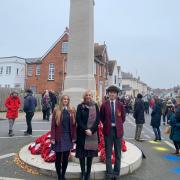 Headteacher Catherine Davis at the war memorial with pupils Michaela and Deniz